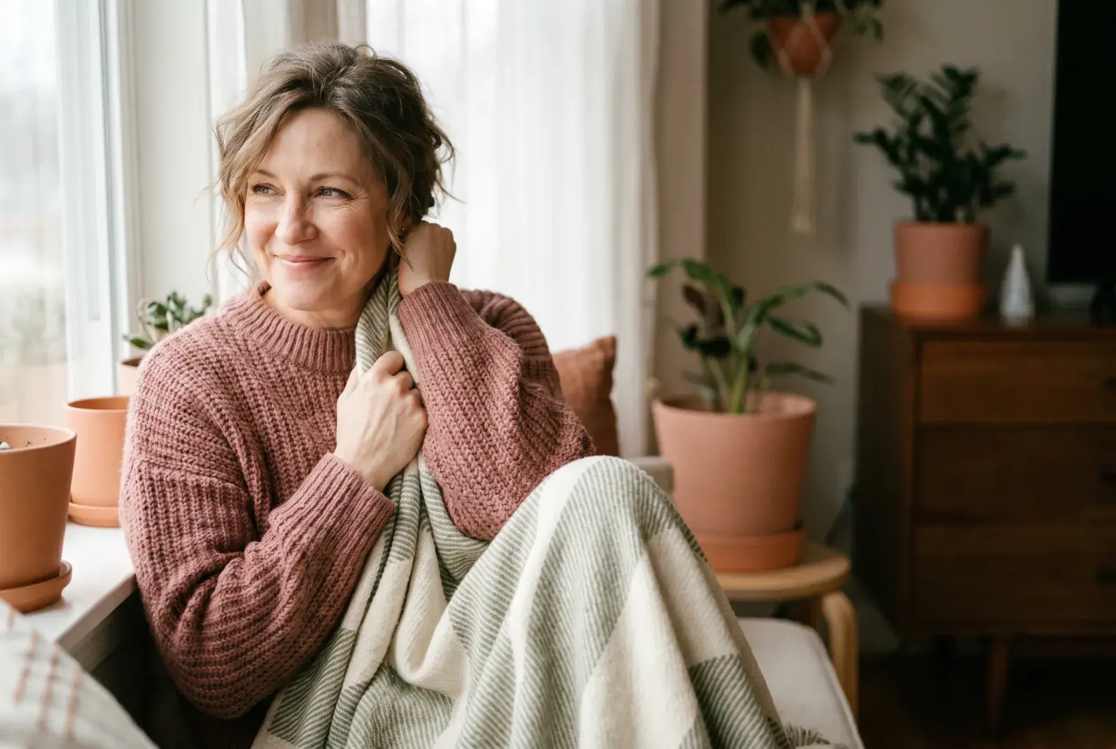 A woman wrapped in a soft blanket with a tender expression